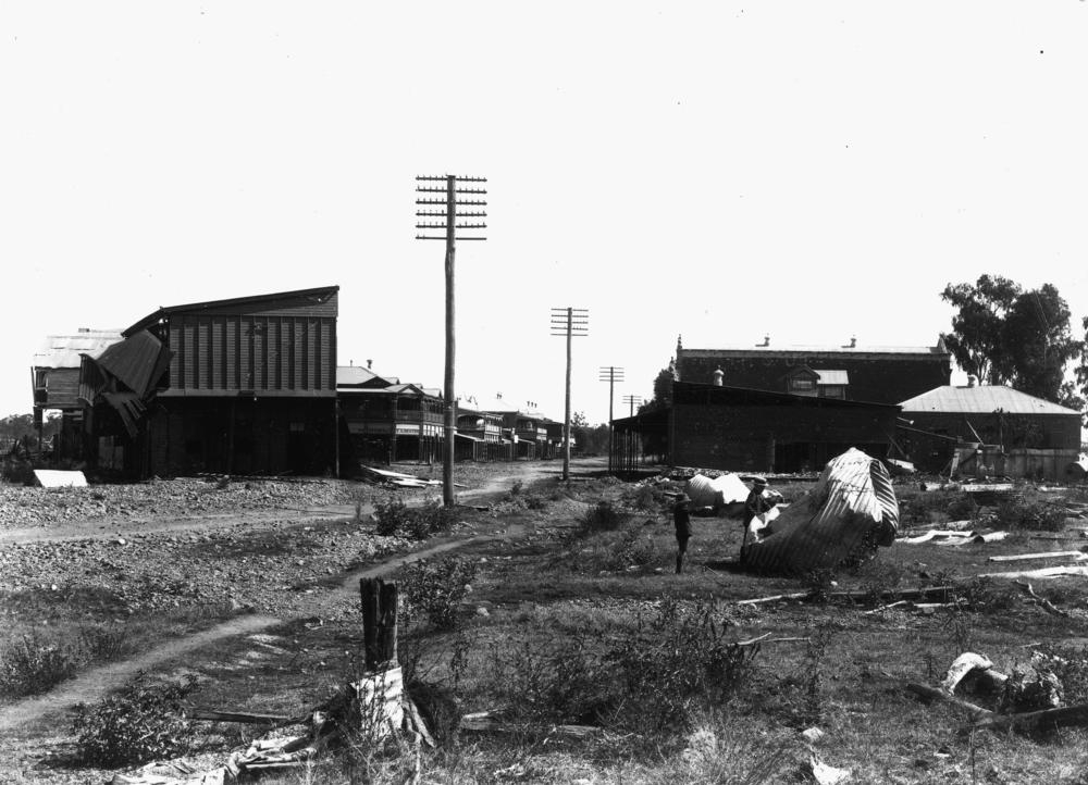 Drummond Street, looking west, showing the wrecked Federal Hotel on left,  'John Oxley Library, State Library of Queensland Image: 191135'.