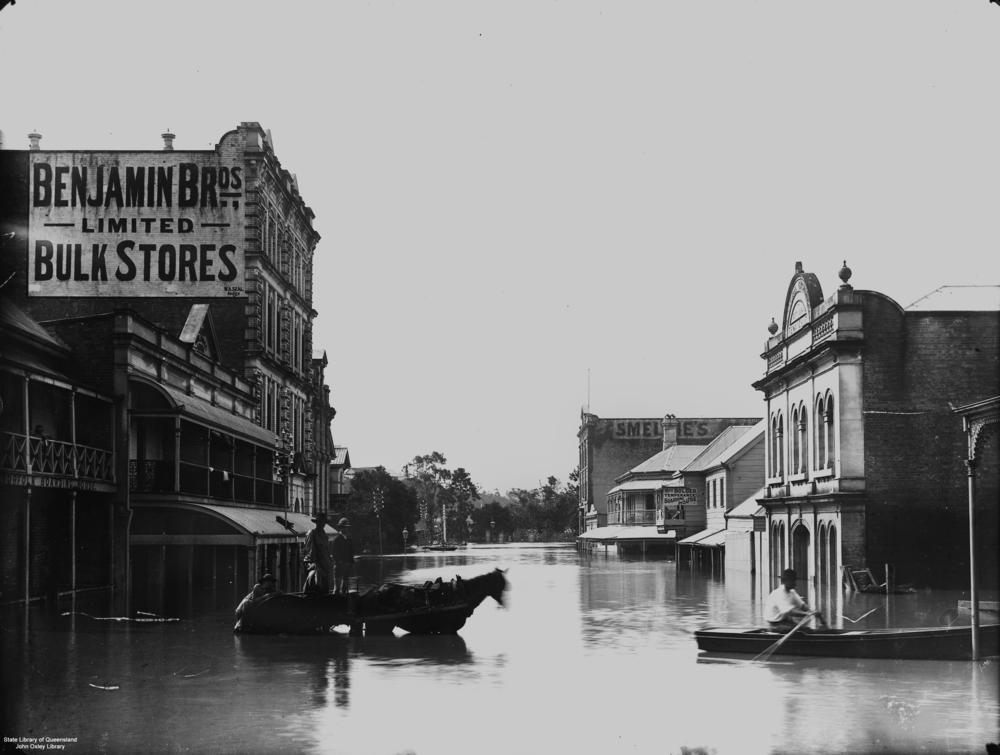 Flood in Edward Street, Brisbane, near Benjamin Bros. Limited Bulk Stores near the corner of Mary Street, Brisbane.  'John Oxley Library, State Library of Queensland   Image: 84987'.
