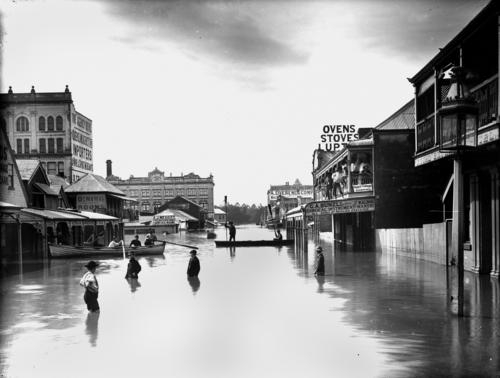 The Royal Exchange Hotel is on the right. Men in the water, in boats and on the balcony of a building in Albert Street during the 1893 flood. 